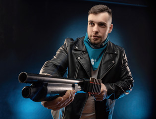 guy in a leather jacket with a shotgun
