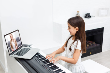 Fototapeta Scene of piano lessons online training or E-class learning while Coronavirus spread out or covid-19 crisis situation, vlog or teacher make online piano lesson to teach students pupils learn from home. obraz