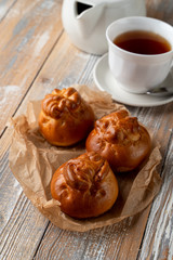 Traditional russian stuffed patties with golden crust, served on wooden table with a cup of tea