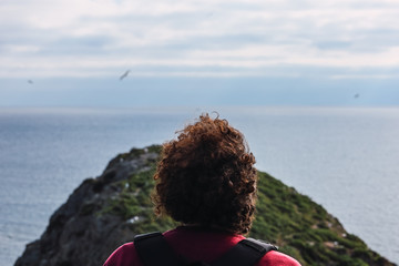 Man is contemplating the ocean in a cliff