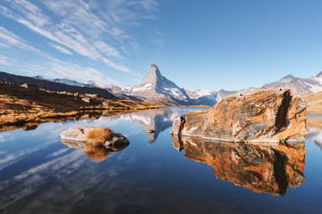 Picturesque landscape with colorful sunrise on Stellisee lake. Snowy Matterhorn Cervino peak with...