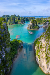 Naklejka premium Aerial view Vung Vieng floating fishing village and rock island, Halong Bay, Vietnam, Southeast Asia. UNESCO World Heritage Site. Junk boat cruise to Ha Long Bay. Famous destination of Vietnam