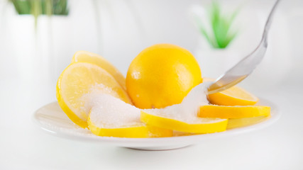 A round slice of yellow lemon is sprinkled with sugar