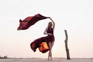 wind inflates a girl's dress in the desert