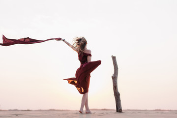 Fototapeta na wymiar wind inflates a girl's dress in the desert