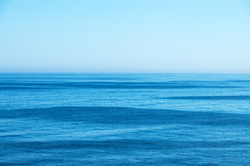 Fototapeta na wymiar Ocean water and blue sky abstract background. Sea water texture closeup