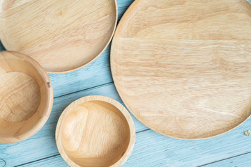 Empty Wooden round board for pizza or food on blue wood table background, top view. Mockup for menu, recipe or any dish.