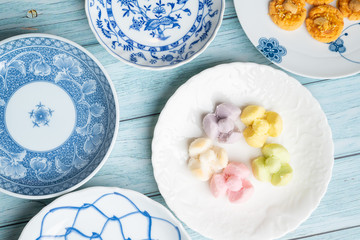 Thai Traditional Cookie on Blue Dish and Wooden Round Board with Blue Rustic Old Wooden Table