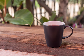 cup of coffee with cream on wooden background	