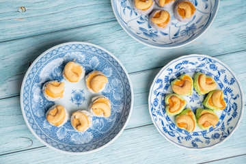 Thai Traditional Cookie on Blue Dish and Wooden Round Board with Blue Rustic Old Wooden Table