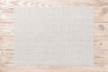 Top view of empty white tablecloth on wooden background with copy space