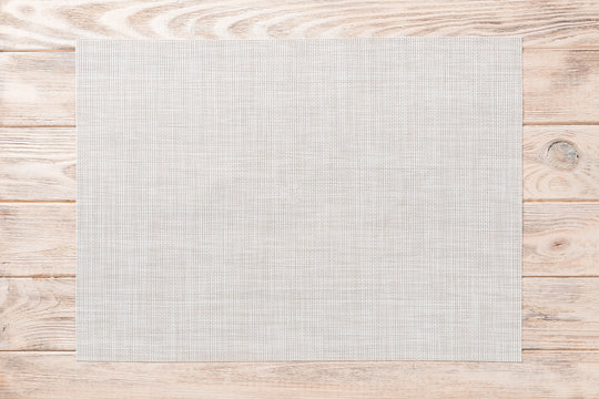 Top view of empty white tablecloth on wooden background with copy space