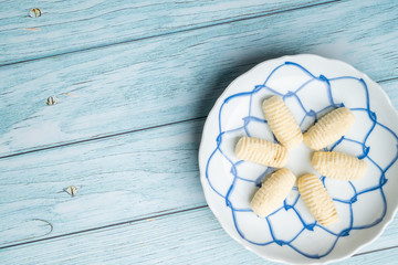 Thai Traditional Cookie on Blue Dish and Wooden Round Board with Blue Rustic Old Wooden Table