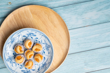 Thai Traditional Cookie on Blue Dish and Wooden Round Board with Blue Rustic Old Wooden Table