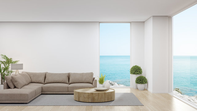 Sofa on wooden floor of large living room in modern house or luxury hotel. Minimal home interior 3d rendering with sky and sea view.