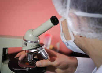 a doctor examines under a microscope