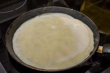 Pancakes are fried in a pan on an induction stove