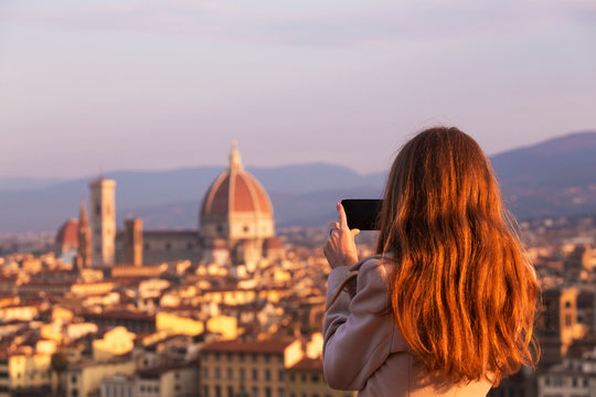 Fototapeta girl making a photo shoot of Florence with the smartphone