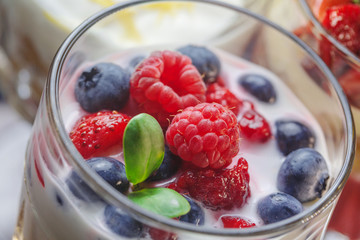 Delicios desert with strawberry and vanilla cream .Fresh berry with crushed nuts in glass cup .Professional and healthy food.