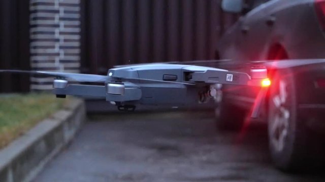 A copter flies up in cloudy weather against a fence
