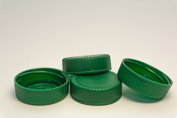 green plastic bottle stoppers on a white background 