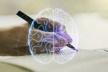 Creative artificial Intelligence concept with human brain sketch and man hand writing in diary on...