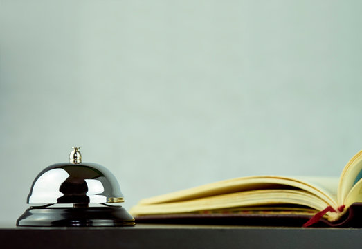 Service bell on a black desk with a reservation book 