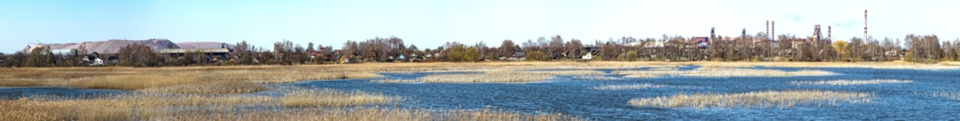 Fototapeta premium Industry and wildlife. Mining industry. The combination of nature and technology. Ore mining. The extraction of potassium salt. Belarus. Salihorsk. The mine on the background of the river.