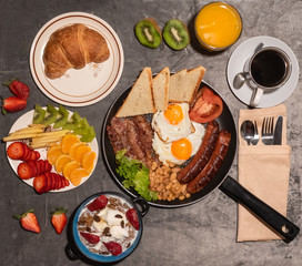 Breakfast served with fresh orange juice, coffee,fruits,croissant,eggs,bacon,sausages,beans and toasted bread