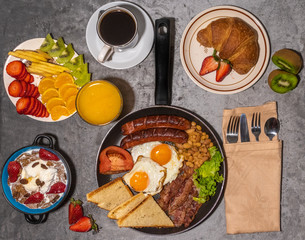 Breakfast served with fresh orange juice, coffee,fruits,croissant,eggs,bacon,sausages,beans and toasted bread