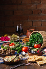 Vegetarian food concept. Set of healthy vegetarian food, salad, boiled, roasted, beans pie, greens and vegetables, stuffed eggplant, vegetables on a wooden table