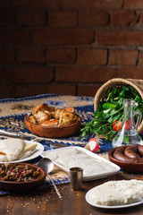 The table dishes set of Georgian cuisine, lots of delicious food, vodka, greens, vegetables and roasted meat