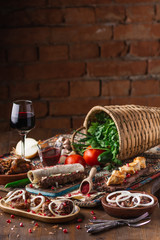 a lot of different dishes on the holiday table. Georgian Cuisine, roasted meet, greens, vegatables, barbeque, red sauce.