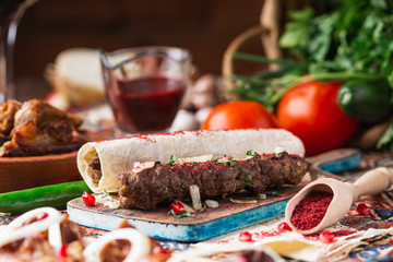 a lot of different dishes on the holiday table. Georgian Cuisine, roasted meet, greens, vegatables, barbeque, red sauce.