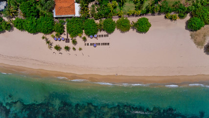 Fototapeta na wymiar Top view on recreation area with umbrellas on the Sanur beach. Aerial view, Sanur, Bali, Indonesia.