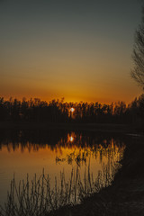 Calm evening sunset on the river mirroring sun