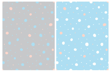 Simple Hand Drawn Irregular Dots Seamless Vector Patterns. White, Blue and Pink Polka Dots Isolated on a Gray Background. Various Size Dots on a Light Blue Layout. Abstract Irregular Dotted Print.