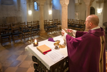 Priester feiert Messe ohne Gläubige