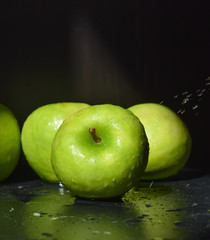 ripe green apples are covered with water drops