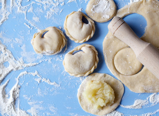 Dumplings with flour on blue background. Traditional dish of ukrainian cuisine