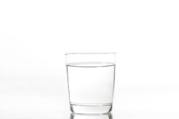 Glass with water and ice on a white background. Glass of mineral water and ice on white background.
