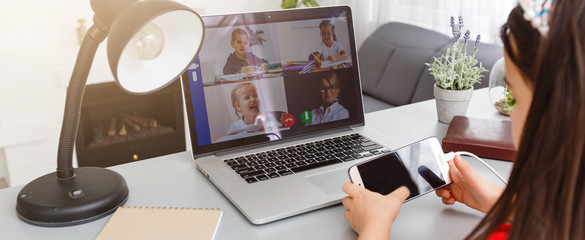 Remote lessons. The child smiles happily and gets knowledge remotely. Little girl study online learning from home with laptop. Online school.