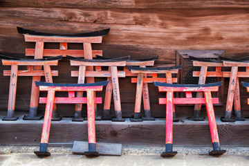 Fototapeta na wymiar Small wooden torii gate with wishes written on them at Shinto shrine. Kyoto. Japan