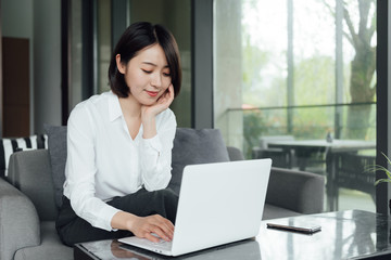 An Asian business woman with short hair is working