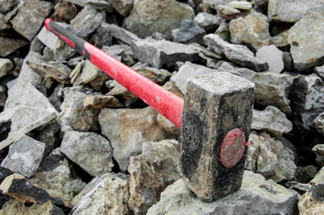 iron hammer breaking stone into pieces. Large sledgehammer for construction - obrazy, fototapety, plakaty