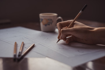 Hands draw a storyboard for the film indoors.