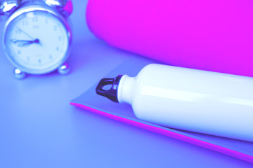 Bright purple yoga mat, alarm clock and bottle of water.