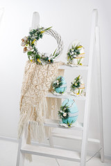 Easter composition of very large eggs on wooden ladder, handmade, Easter wreath on the door, prepared for Easter holiday