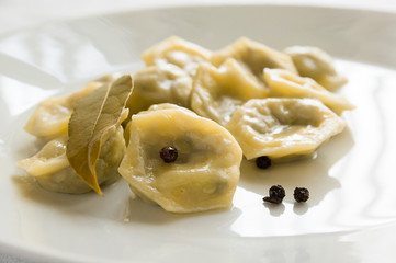 pelmeni with black pepper and bay leaf