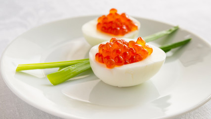 egg halves with red caviar served with green onion